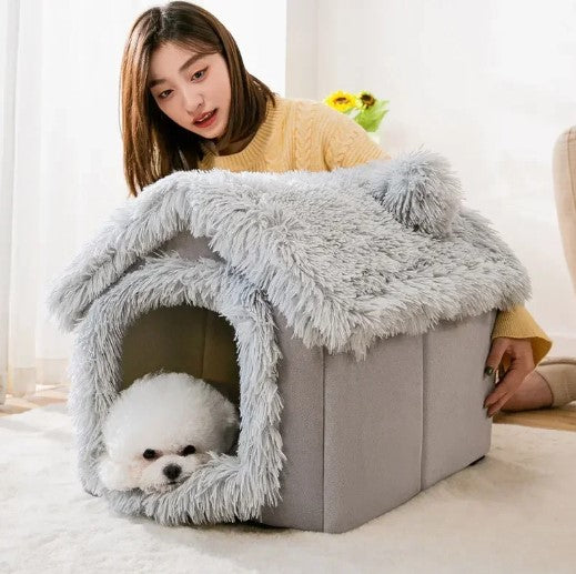 White small dog in cozy indoor dog house bed