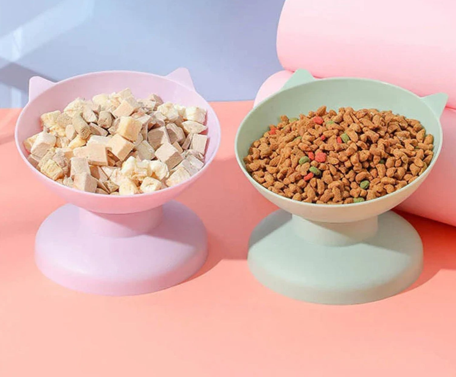 Pink elevated dog bowl with freeze-dried pet food and green elevated dog bowl with dog kibble