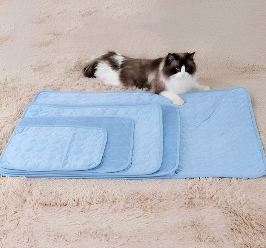 Black and white cat lying on stacked cooling mats for pets in multiple sizes