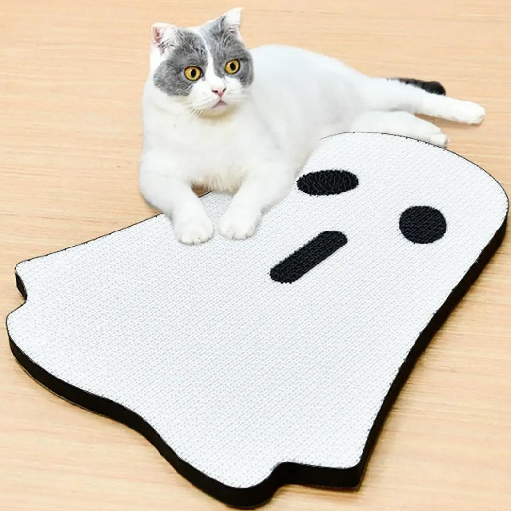 Cat lying on white ghost-shaped scratching board
