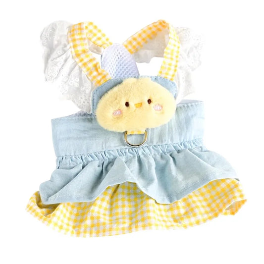 Small dog wearing pink doll-style harness with denim skirt and matching leash