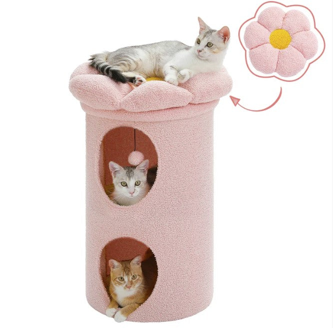 A pink double layers cat house with three cats are relaxed on it.