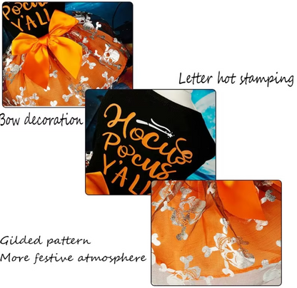 Small dog wearing a Halloween-themed dress with bow and puffy skirt.