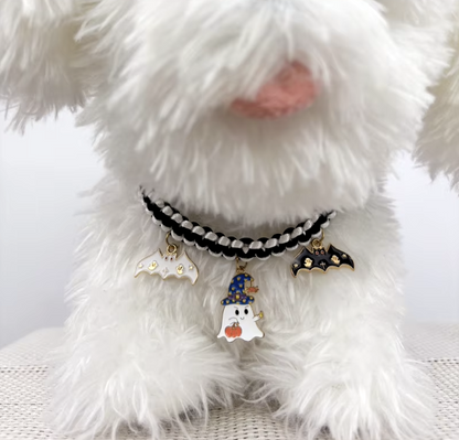 Cat wearing a Halloween breakaway collar with a small pumpkin pendant and festive woven design.