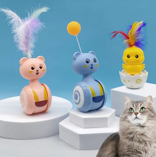 Cat sitting in front of three interactive cat tumbler toys with rotating ball and feather wand