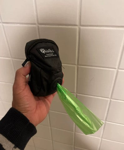 Hand holding a portable dog treat pouch with waste bag dispenser, ideal for walking, hiking, and outdoor training - Customer review photo