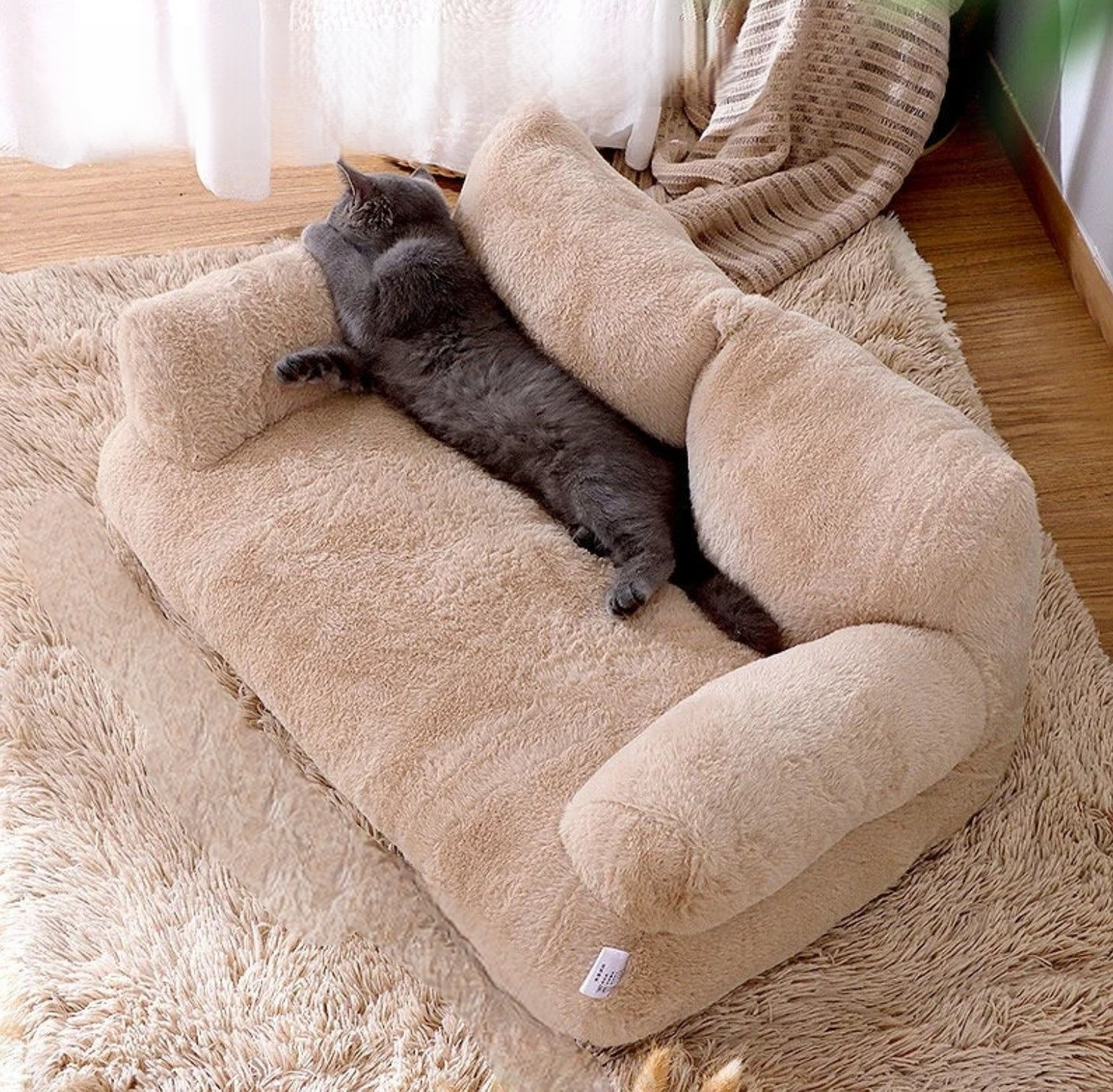 A black cat lounging comfortably on a khaki cat sofa bed