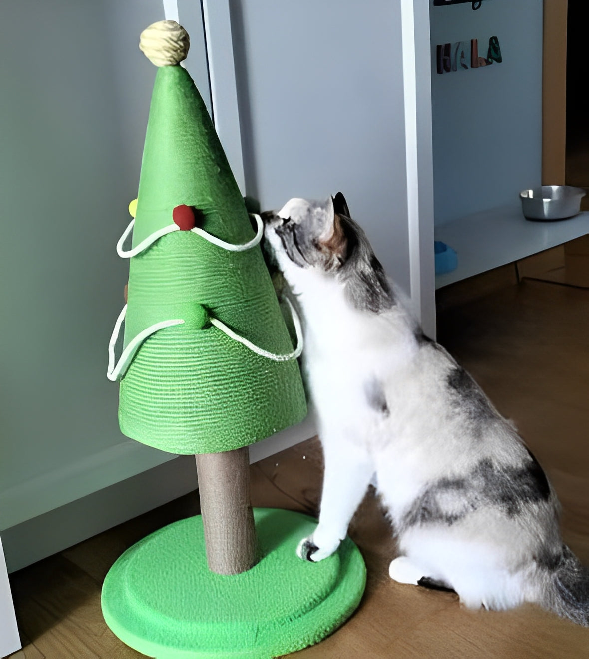 Cat sniffing green Christmas tree-shaped cat scratching post with colorful pom-poms on floor - Customer review photo