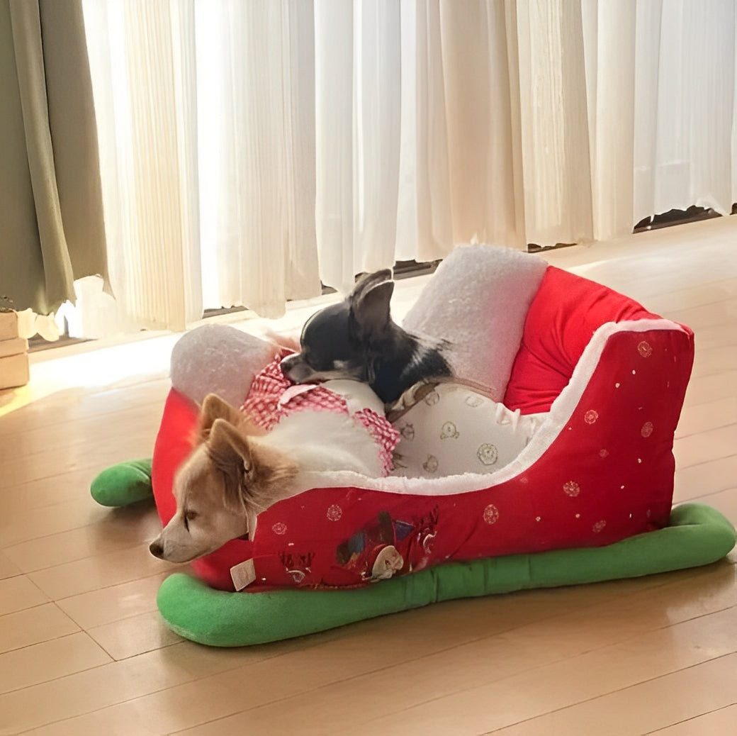 Two dogs comfortably lying inside a Christmas sleigh-shaped dog bed
