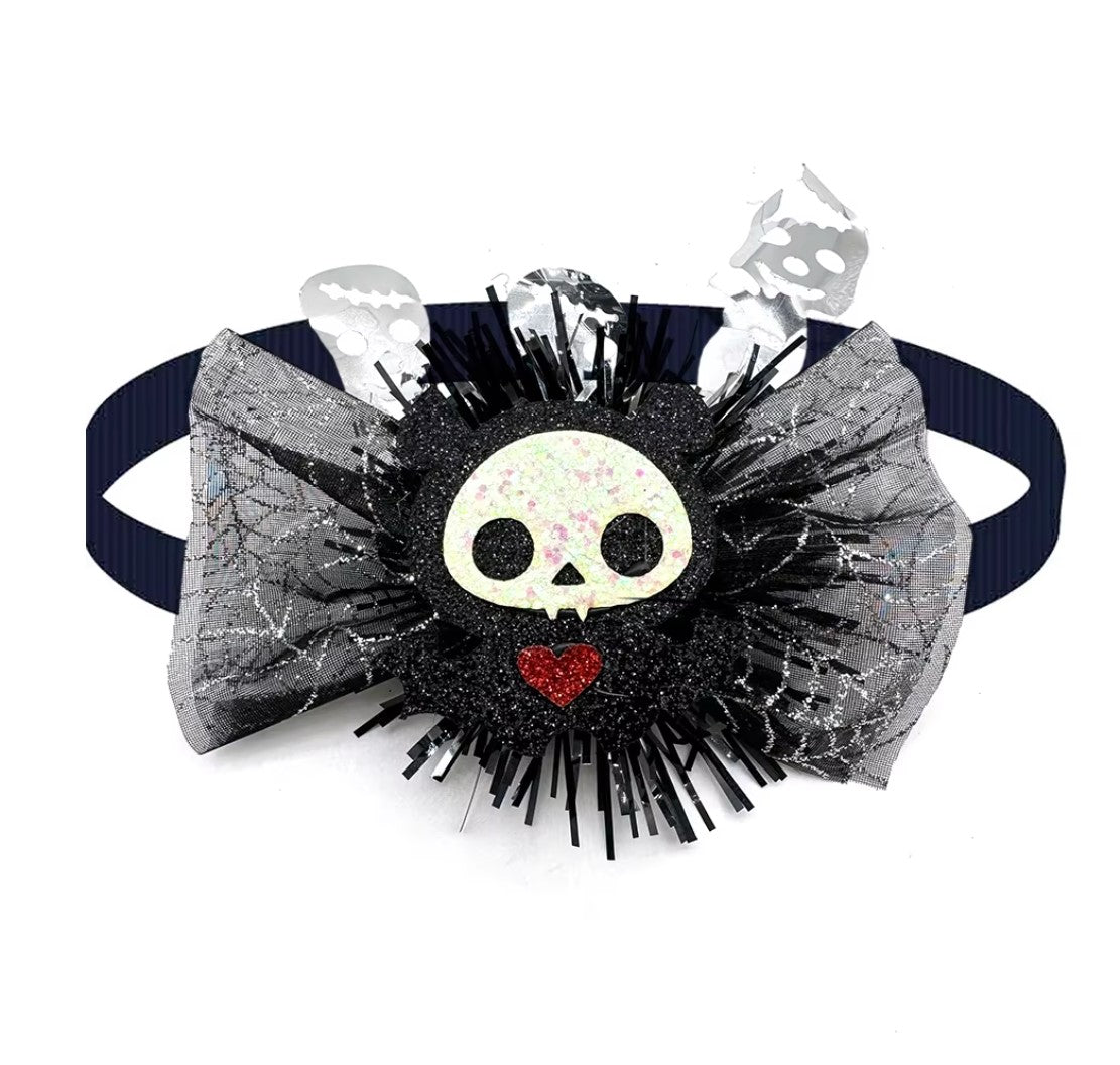 Dog wearing a cute pumpkin and skull Halloween bow tie for festive fun.
