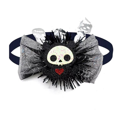 Dog wearing a cute pumpkin and skull Halloween bow tie for festive fun.