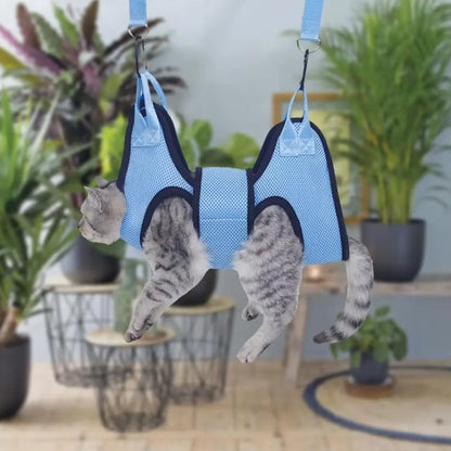 Cat suspended in a grooming hammock while getting its nails trimmed, safe and stress-free grooming tool