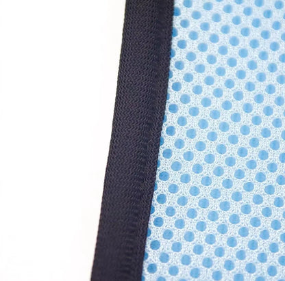 Cat suspended in a grooming hammock while getting its nails trimmed, safe and stress-free grooming tool