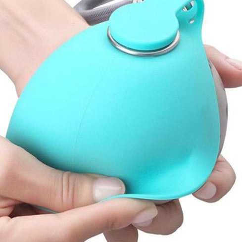 Dog travel water bottle with soft silicone skin in hand, designed for easy hydration on-the-go.