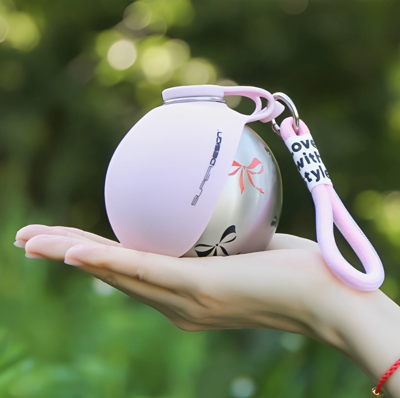 Dog Travel Water Bottle The Nomad™ Kinetic Hydration Orb held in a hand outdoors, sleek design for pets.