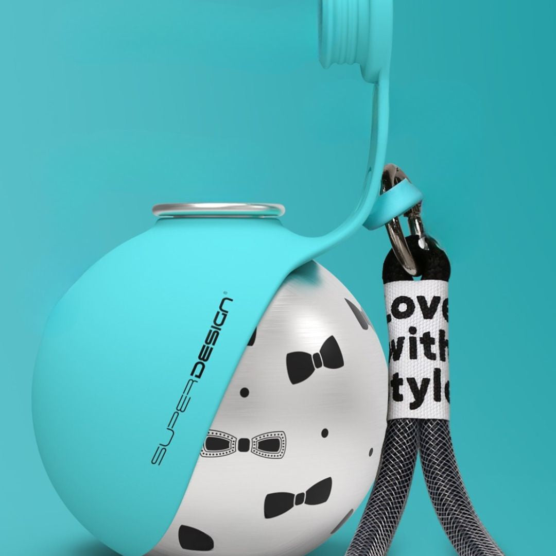 Dog travel water bottle The Nomad™ Kinetic Hydration Orb in turquoise with bow tie design and leash attachment.