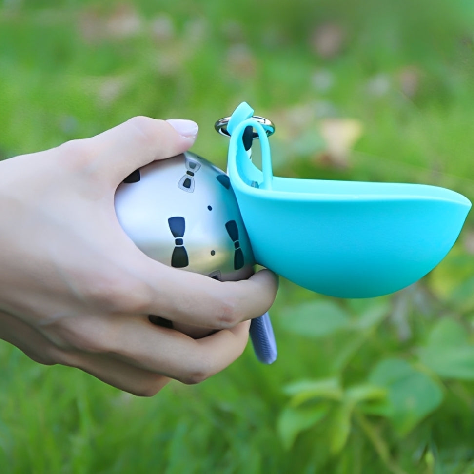 A person holding the Dog Travel Water Bottle The Nomad™ Kinetic Hydration Orb in a green outdoor setting.