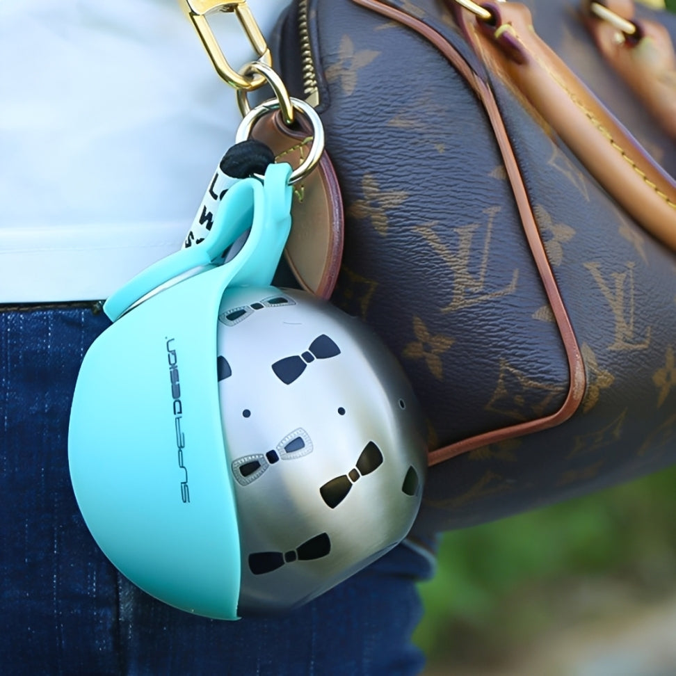 Dog travel water bottle in a stylish carrying case attached to a handbag for pet hydration on the go.