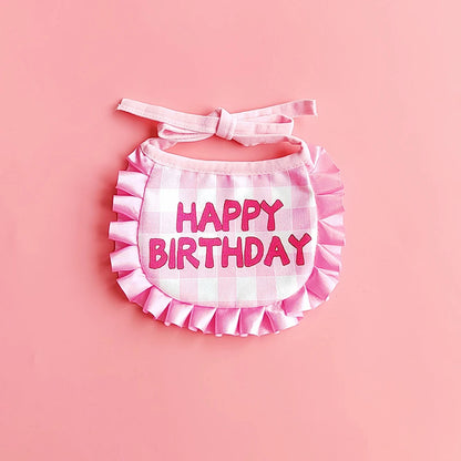 Small dog wearing birthday scarf and hat set for celebration or party