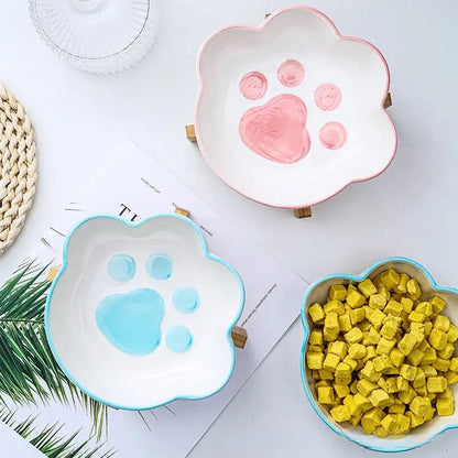 Cat paw-shaped ceramic pet bowl with bamboo stand, perfect for cats and dogs.