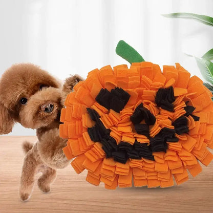 Dog sniffing a Halloween-themed pumpkin snuffle mat for hidden treats.