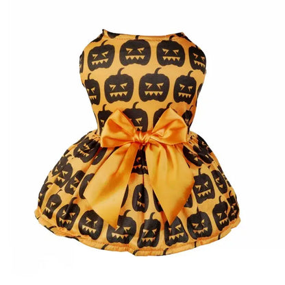 Small dog wearing a Halloween-themed dress with bow and puffy skirt.