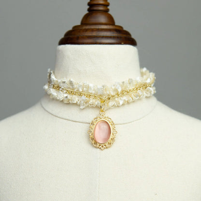 Small dog wearing gem pendant pearl necklace with lace accents