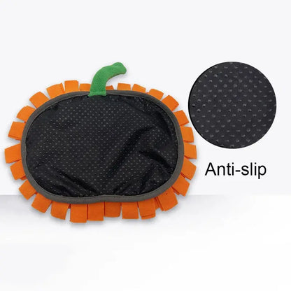 Dog sniffing a Halloween-themed pumpkin snuffle mat for hidden treats.