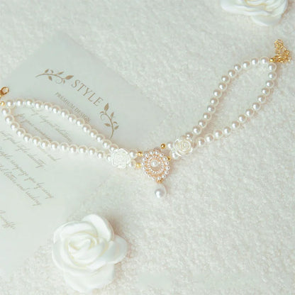 Small dog wearing gem pendant pearl necklace with lace accents