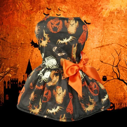 Small dog wearing a Halloween-themed dress with bow and puffy skirt.