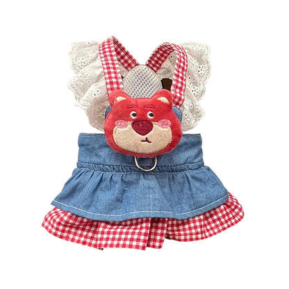 Small dog wearing pink doll-style harness with denim skirt and matching leash