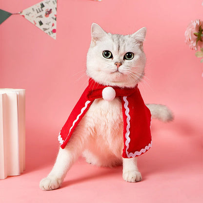 Adorable cat wearing reindeer antlers, Santa hat, red scarf, and holiday cloak for Christmas celebrations