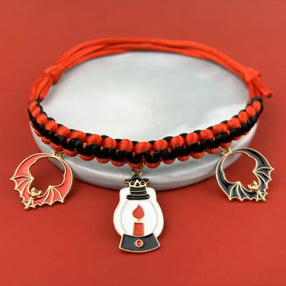 Cat wearing a Halloween breakaway collar with a small pumpkin pendant and festive woven design.