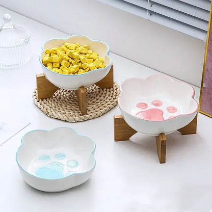 Cat paw-shaped ceramic pet bowl with bamboo stand, perfect for cats and dogs.