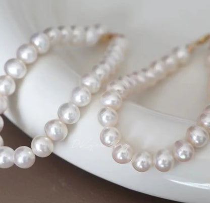 Small dog wearing gem pendant pearl necklace with lace accents