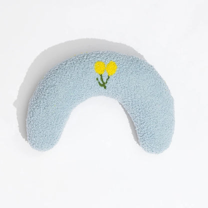 Cat resting on small U-shaped pet pillow in soft plush fabric