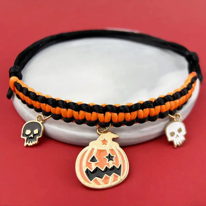 Cat wearing a Halloween breakaway collar with a small pumpkin pendant and festive woven design.