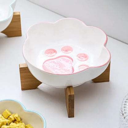 Cat paw-shaped ceramic pet bowl with bamboo stand, perfect for cats and dogs.