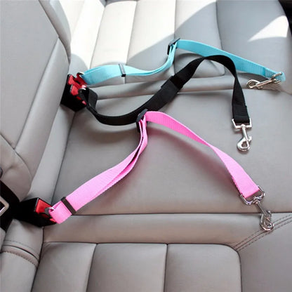 Dog wearing harness attached to car seat belt safety protector