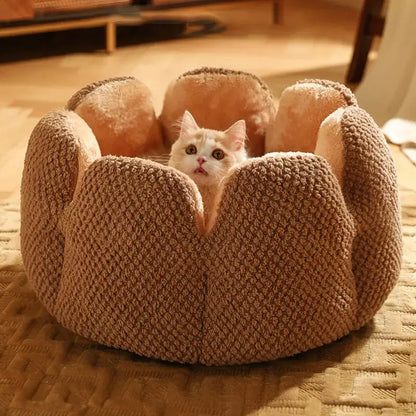 Small cat sleeping in a soft round plush pet bed with striped design
