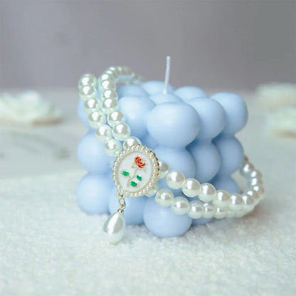 Small dog wearing gem pendant pearl necklace with lace accents