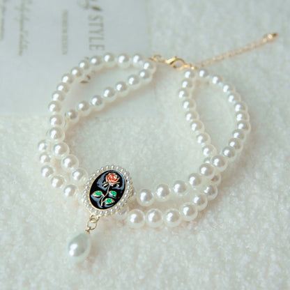 Small dog wearing gem pendant pearl necklace with lace accents