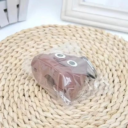 Poop-shaped pet waste bag dispenser clipped to a dog leash